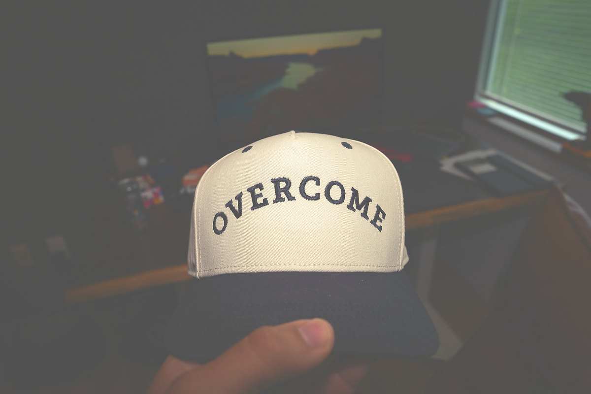 Overcome Media branded hat photographed as part of a creator portfolio detail shot