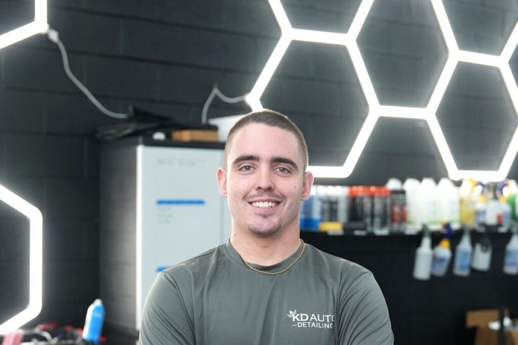Local business owner standing in an auto detailing shop for a website and marketing project